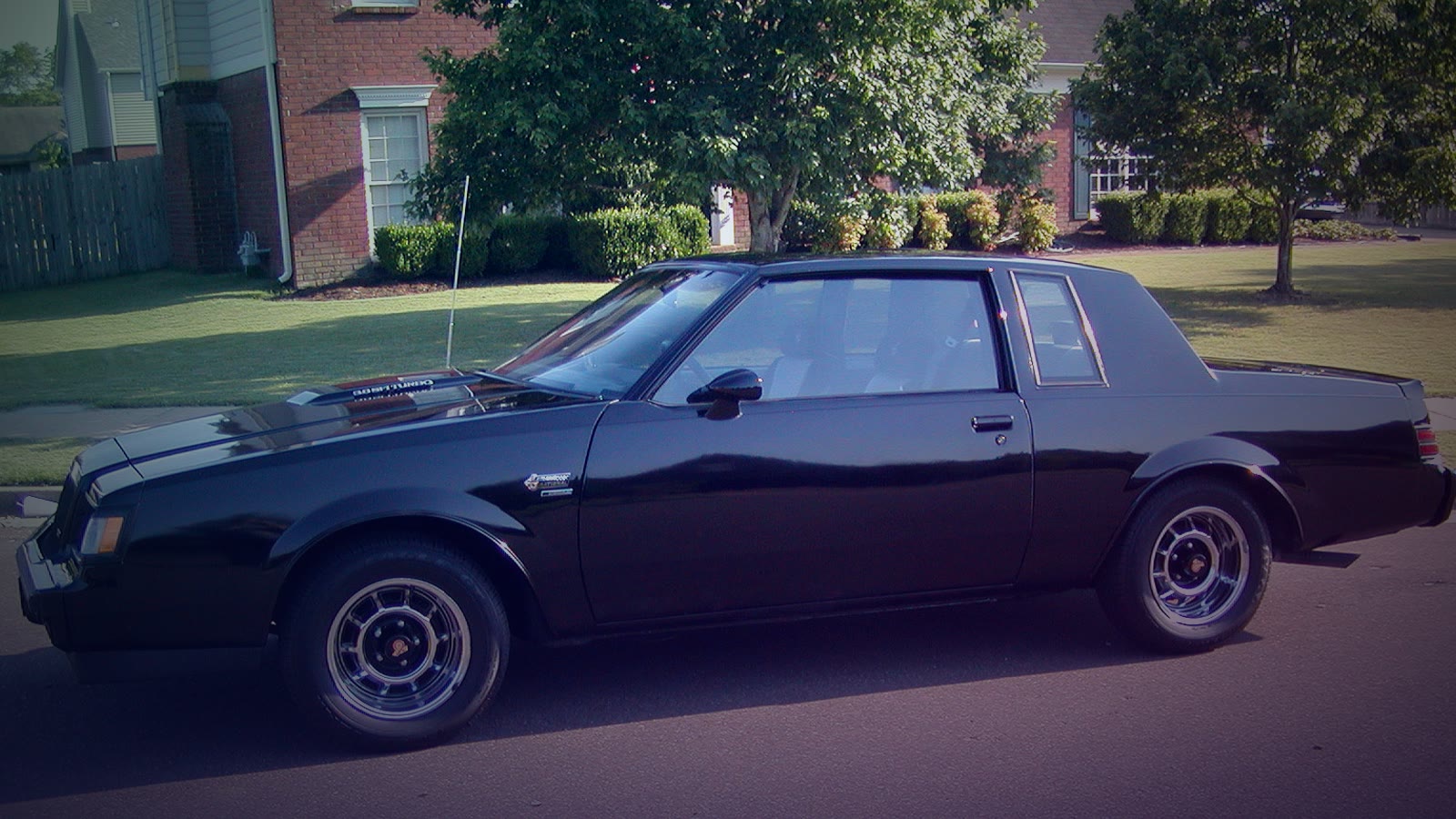 A black 1987 Buick Grand National, a classic 1980s muscle car with the distinctive dark styling that earned it the 'Darth Vader' nickname