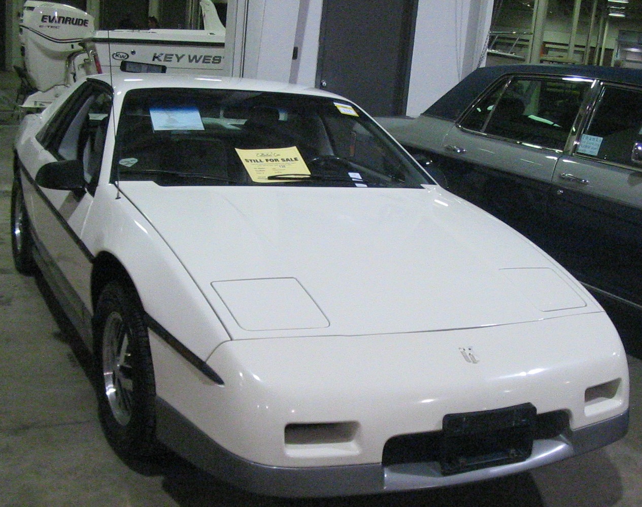 A 1985 Pontiac Fiero GT sports car, a classic 1980s two-seater with distinctive wedge styling, photographed at a classic car auction