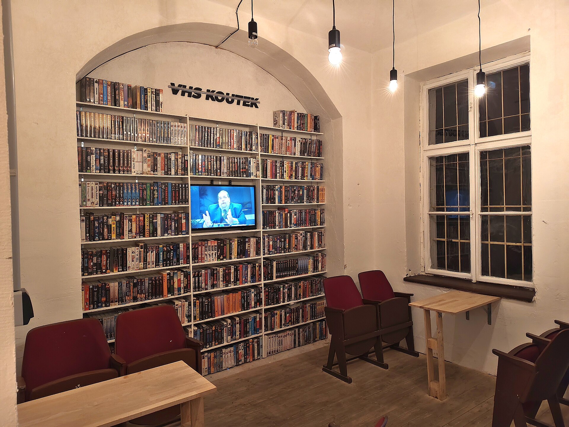 Interior of a cinema with VHS tapes displayed on shelves in a dedicated section