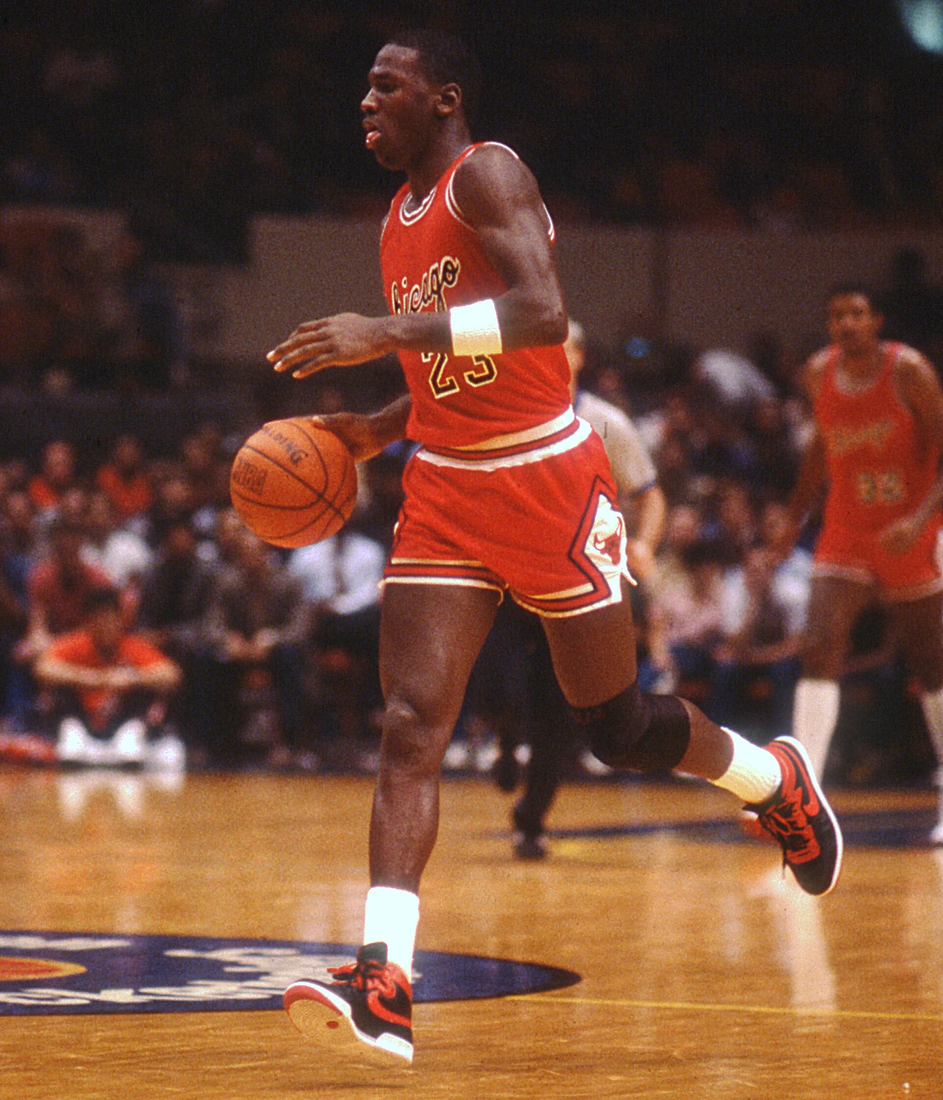 Michael Jordan in Chicago Bulls uniform during an early NBA game at Madison Square Garden in 1984, setting up the offense